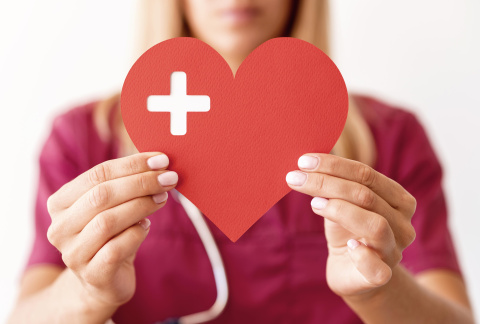 defocused-female-doctor-holding-paper-heart